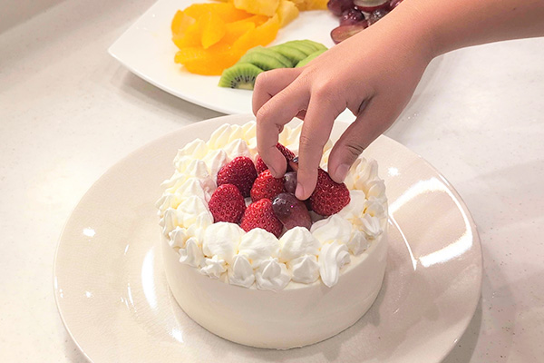 「デコるだケーキ」にいちごをのせる様子