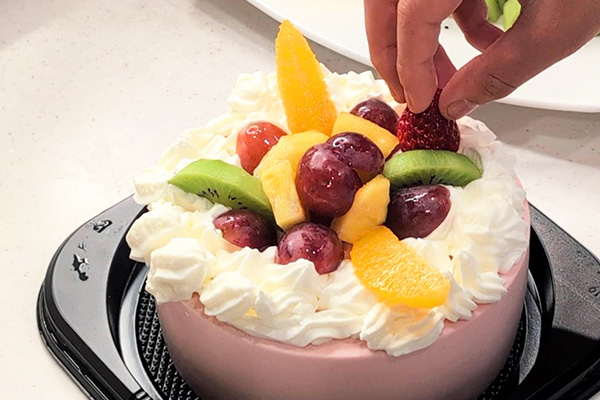 「デコるだケーキ」にフルーツをのせて飾り付け