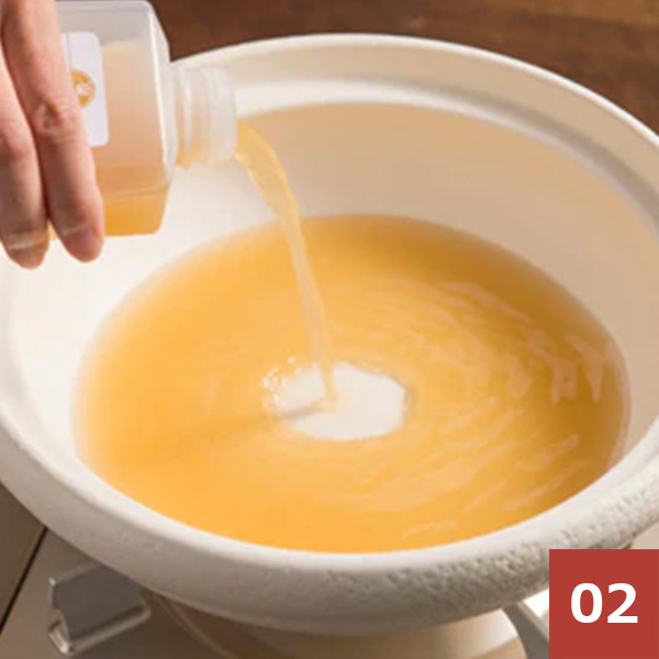 鍋にもつ鍋のスープを入れる