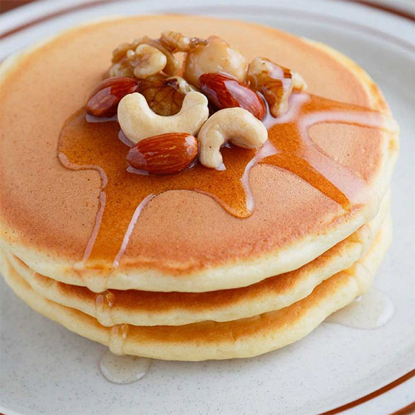 パンケーキにハチミツとナッツをかけた様子