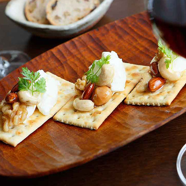 ビスケットにのせてお酒のおつまみにする様子